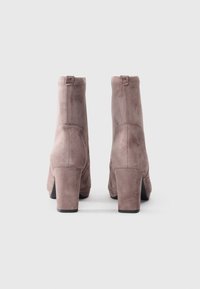 Suede ankle boots in soft taupe with a chunky heel and rounded toe. Features minimal stitching and a stitched logo on the back heel.