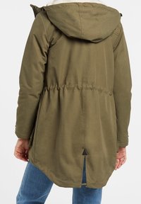 Parka vert olive avec capuche, taille cintrée et fente arrière. Doublure intérieure douce, avec surpiqûres contrastées et tissu résistant.