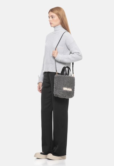 Borsa in shearling grigia di forma rettangolare, con manici neri, inserti dorati e lettering in rilievo sul davanti.