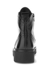 Bottine en cuir verni noir avec une texture lisse, bout arrondi et fermeture éclair latérale. Semelle épaisse noire avec un léger talon.