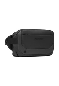 Bolso bandolera negro hecho de tela texturizada, con un bolsillo delantero con cremallera, correa ajustable y detalle del logo. Forma rectangular compacta.