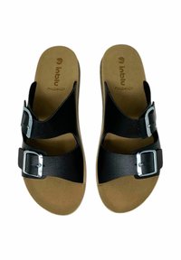 Sandali neri con due fibbie regolabili, suola piatta e soletta imbottita con una base in cuoio chiaro. Texture sintetica liscia.