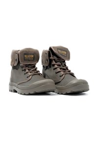 Braune Canvas-Ankle-Boots mit Gummisohlen, verstärkten Ösen und einem umklappbaren Schaft mit einem Logo-Patch. Strukturierte Oberfläche mit Schnürsenkeln.