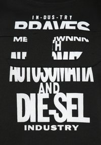Čierne tričko s výrazným bielym grafickým textom rôznych veľkostí a štýlov, vrátane slov „BRAVES“, „AUTOSMATIK“ a „DIESEL“.