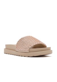 Lichtroze slide-sandalen met een geweven bovenkant, platte beige zool en gestructureerde details. Open teenontwerp voor gemakkelijk aan- en uittrekken.