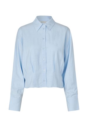 Lys blå kort knappeskjorte laget av lin. Har klassisk krage, lange ermer og subtile sømdetaljer foran.