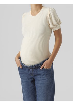Cream ribbed top with puff sleeves paired with blue denim jeans, featuring an elastic waistband and a relaxed fit around the hips.