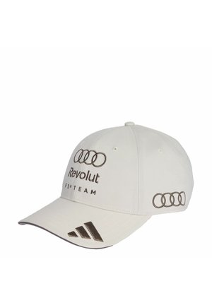 Biała czapka z daszkiem z logo Audi czterech pierścieni, napisem "Revolut F1 Team" z przodu oraz logo Adidas na daszku.