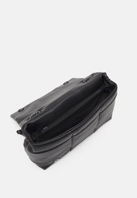 Borsa a spalla in ecopelle nera, forma rettangolare con texture soffice, chiusura superiore a zip e dettagli in catena. L'interno presenta una tasca con zip.