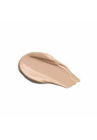 Trucco crema beige con una consistenza liscia e lucida, modellato a forma di goccia con una leggera lucentezza su uno sfondo bianco.