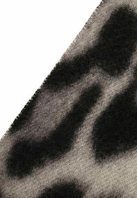 Grauer Stoff mit einem schwarzen Leopardenmuster und einer weichen, strukturierten Oberfläche. Die Kanten sind ordentlich genäht, was ein Augenmerk auf Details zeigt.