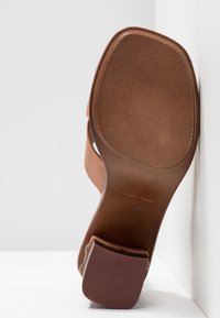 Sandale en cuir marron avec un bout carré, un talon bloc et une taille 37 marquée sur la semelle, sur fond blanc.