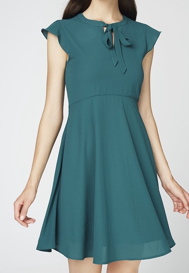 Robe bleu sarcelle avec manches courtes, corsage ajusté et jupe évasée. Présente un col rond avec un lien à l'avant et une texture de tissu lisse.