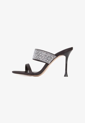 Sandale noire à talons hauts au design élégant, dotée d'une large bride scintillante ornée de petits strass en argent et d'une fine bride au niveau des orteils.