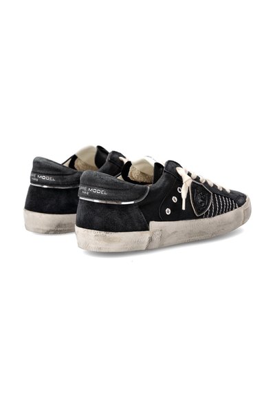 Baskets en suède noir avec un devant texturé, lacets blancs et semelle gris clair. Présente des accessoires en métal argenté et un logo de la marque sur le talon.