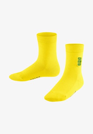 Gelbe Baumwollsocken mit gerippten Bündchen, auf der Seite mit einer grünen Bärengrafik und einem bedruckten Logo an der Unterseite. Mittellange Ausführung bis zur Wade.