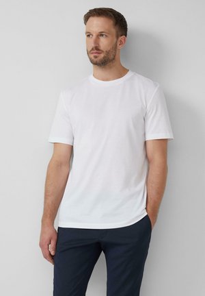 Camiseta blanca de cuello redondo y manga corta, hecha de una mezcla de algodón, con una textura suave, dobladillo recto y construcción de costura lateral.