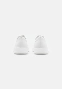 Witte sneaker van soepel leer, met een ronde neus, gewatteerde kraag en een gestructureerde zool. Minimalistisch ontwerp zonder zichtbare logo's of patronen.