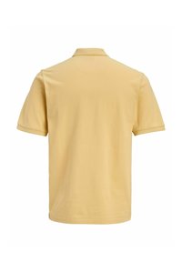 Απλό ανοιχτό κίτρινο κοντομάνικο πόλο πουκάμισο, εμφανιζόμενο από πίσω, με απλό γιακά και χωρίς ορατά λογότυπα ή σχέδια.