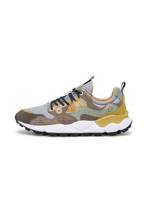 Freizeit-Sneaker mit gemischten Materialien in Grau, Braun, Gelb und Grün, mit schwarzen Schnürsenkeln, dicker weißer Sohle und schwarzem Profil an der Unterseite.
