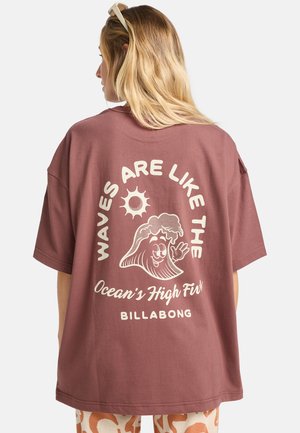 Maronfarvet oversized T-shirt med grafisk print på ryggen, der viser en smilende bølkefigur, en sol og tekst. Fremstillet af bomuldsmateriale med en afslappet pasform.