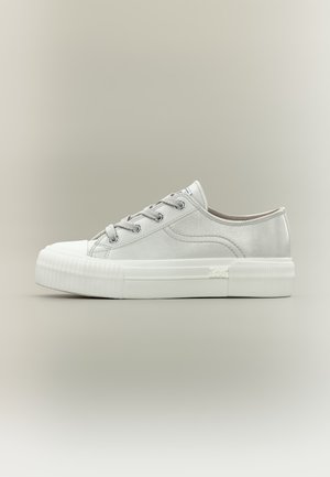 Λευκό αθλητικό παπούτσι χαμηλού τύπου με χοντρή ραβδωτή λαστιχένια σόλα, λευκά κορδόνια και διακριτικές ραφές, παρουσιασμένο σε ουδέτερο φόντο.