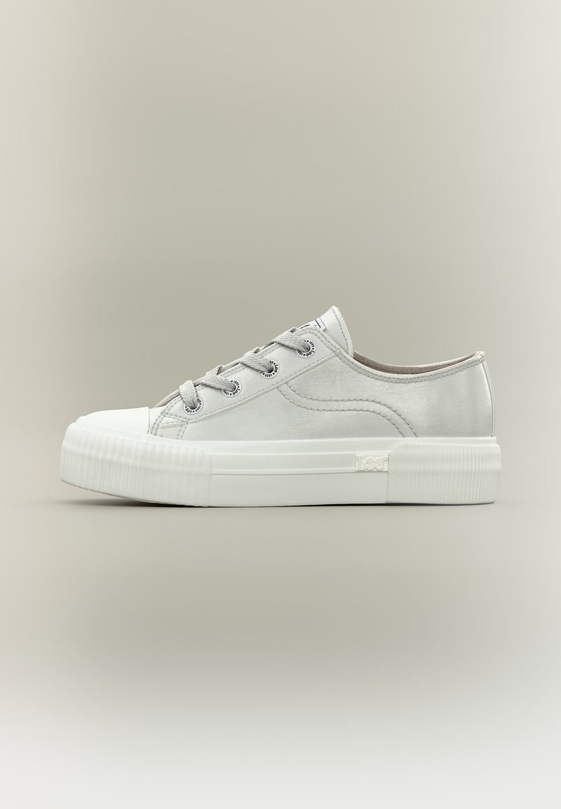 Λευκό αθλητικό παπούτσι χαμηλού τύπου με χοντρή ραβδωτή λαστιχένια σόλα, λευκά κορδόνια και διακριτικές ραφές, παρουσιασμένο σε ουδέτερο φόντο.