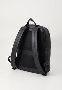 Black backpack with padded mesh back, adjustable straps, and zipper closure. Smooth leather accents and a side pocket for convenience.