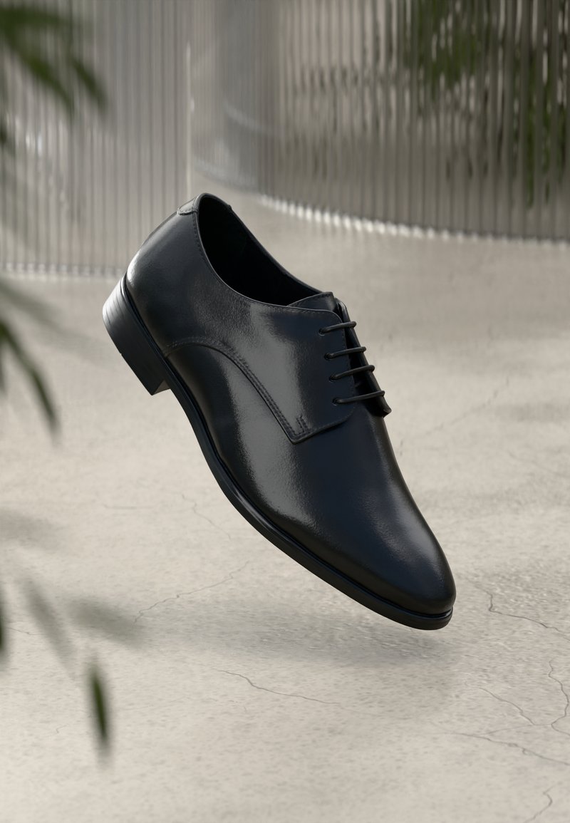 Schwarze Lederdressschuhe mit glatter Oberfläche, runder Spitze und minimaler Schnürung. Verfügen über einen niedrigen Absatz und ein elegantes Design vor einem neutralen Hintergrund.