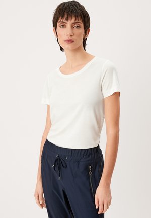 T-shirt blanche à manches courtes avec un col rond, silhouette ajustée et texture douce. Assorti à un pantalon noir marine à enfiler avec poches zippées.