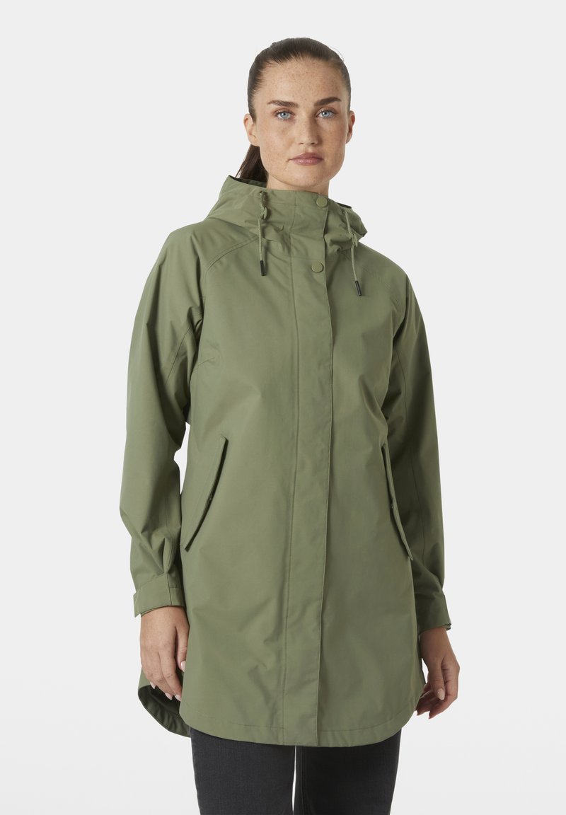 Αδιάβροχο μπουφάν σε ελαιώδες πράσινο με κουκούλα, που διαθέτει φερμουάρ και κούμπωμα με πατιλέτα, δύο πλαϊνές τσέπες και ελαφρώς μακρύτερη πλάτη για επιπλέον κάλυψη.
