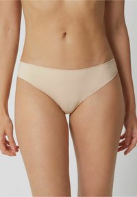 Beige bikini brief with a smooth texture, medium coverage, and a seamless design. Features a low-rise waistband and is made of stretchable fabric.