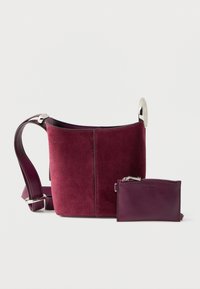 Τσαντάκι κουβάς από σουέντ μπορντό με επίχρυσα ασημένια μεταλλικά στοιχεία και αποσπώμενη θήκη καρτών σε ταιριαστό χρώμα. Λουρί από λείο δέρμα με διακοσμητικές λεπτομέρειες.