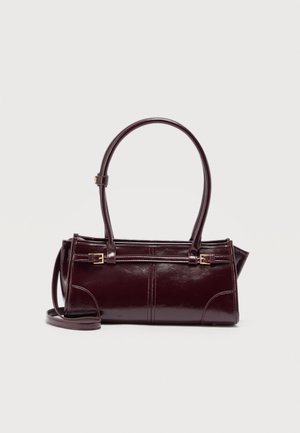 Dark burgundy rectangular leather handbag with double handles, adjustable side buckles, and a thin detachable shoulder strap on white background.