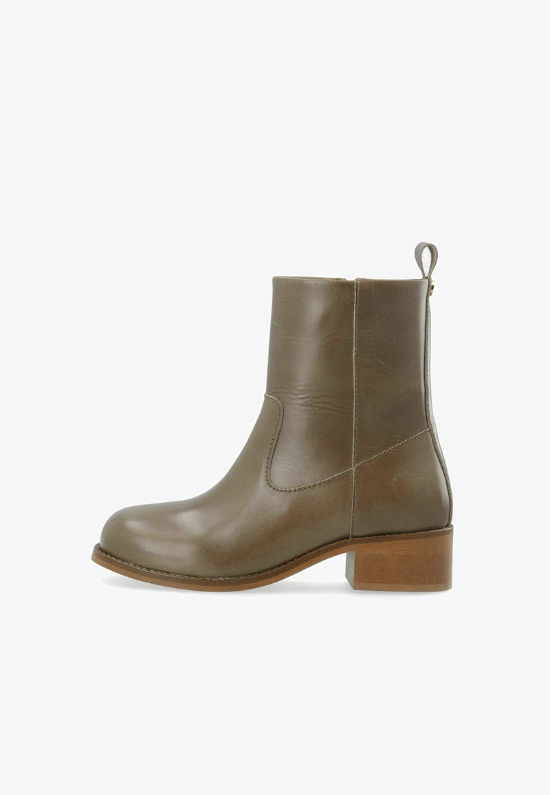Bottine en cuir vert olive avec un petit talon bloc en bois et un onglet à l'arrière, présentée en profil latéral sur fond blanc.