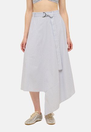 Femme portant une jupe midi portefeuille légère à rayures avec un ourlet asymétrique et une ceinture nouée, assortie à des chaussures métalliques à lacets.