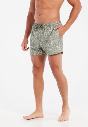 Costumi da bagno da uomo in verde oliva con stampa di palme. Vita elasticizzata con cordoncino, tasca laterale, tessuto leggero, design informale.