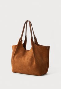 Bruine suède tote bag met twee bruine leren handvatten, met een gladde, gestructureerde afwerking en minimalistisch ontwerp.