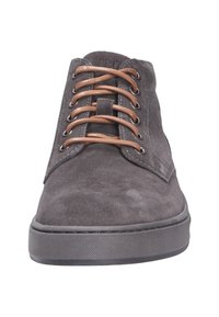 Las botas chukka de ante gris presentan cordones marrones, una parte superior cosida y una suela de goma negra texturizada, diseñadas para un uso informal.