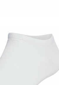 Calza bianca alla caviglia realizzata in tessuto morbido e elasticizzato. Presenta un design a taglio basso con bordi a costine. Texture liscia senza motivi o accenti visibili.