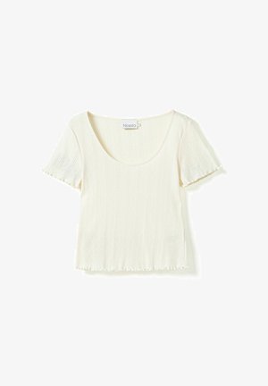 Crème korte mouw top met een ronde hals, gestructureerd ribbelpatroon en franjes langs de zoom en mouwranden. Merkenlabel zichtbaar.