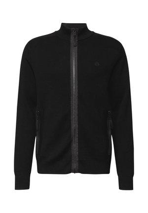 Zwarte ritstrui met hoge kraag, twee zijzakken en een textuurstof. Bevat een klein logo op de borst en geribde mouwen.