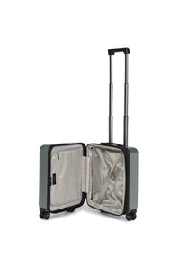 Valigia rigida da cabina di colore grigio scuro, con manico nero estensibile, due ruote lisce e un interno beige dotato di cinghie e una tasca con zip.