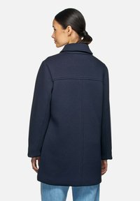 Marineblauwe jas met een gestructureerde kraag, lange mouwen en een rechte silhouet. Heeft een nette achternaad voor een moderne uitstraling.