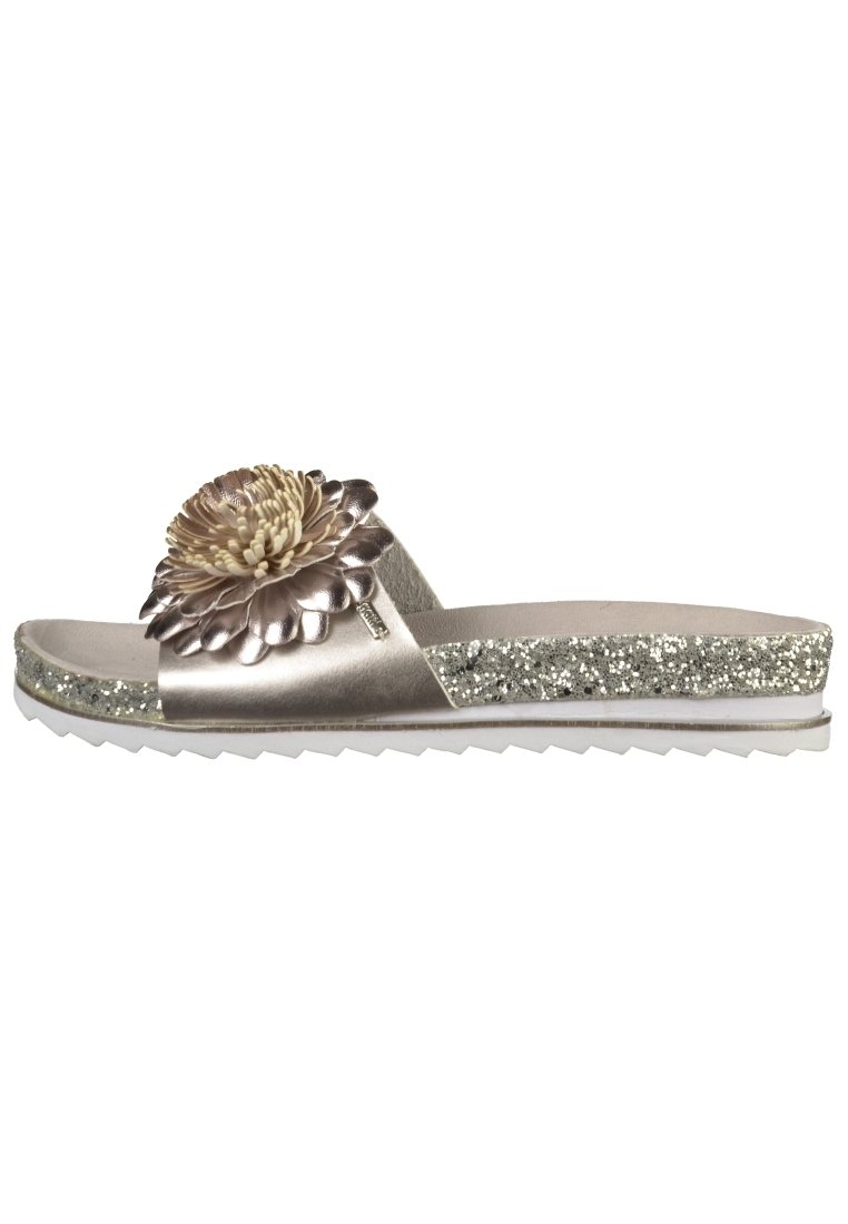 Metallisk silverfärgad slide sandal med en stor texturerad blommaaccent och en glittrig mellansula. Har en vit gummisula med ett zigzag-mönster.