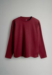 Burgunderfarbendes Langarmshirt aus Baumwolle. Mit Rundhalsausschnitt, lockerer Passform und glatter Textur ohne sichtbare Muster oder Akzente.