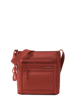 Rustfarvet crossbodytaske med justerbar rem, lynlåslomme foran og Hedgren-logo på en glat stofoverflade.