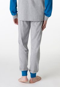 Pantaloni da pigiama in cotone grigio con polsini blu, dotati di una vita elastica e di una texture morbida, visti da dietro senza calzature.