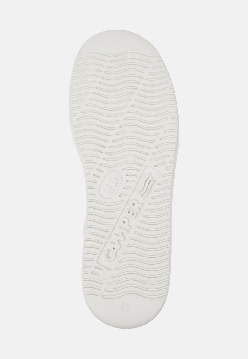 Sole of a white Camper shoe with wave-pattern tread, brand name embossed, and size 38 marked near the heel.