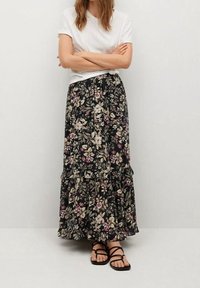 Jupe longue fleurie avec un fond noir, présentant un design à volants et un motif varié de fleurs dans des nuances de rose, crème et vert.